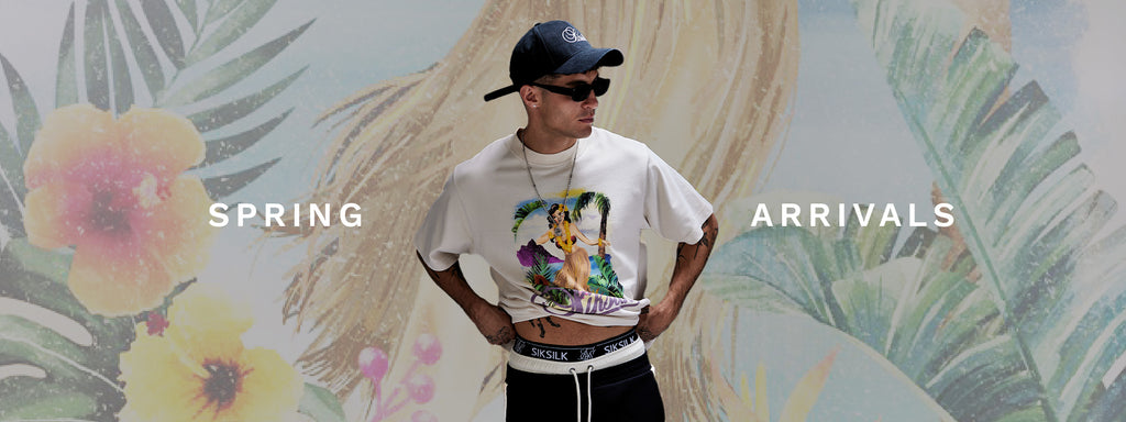 Spring Arrivals. SikSilk model posing in front of floral image, wearing new Ecru Graphic T-Shirt