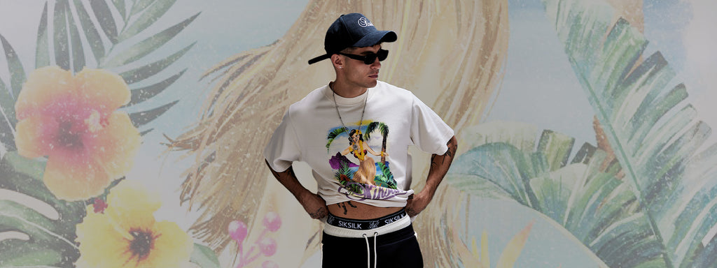 Spring Arrivals. SikSilk model posing in front of floral image, wearing new Ecru Graphic T-Shirt