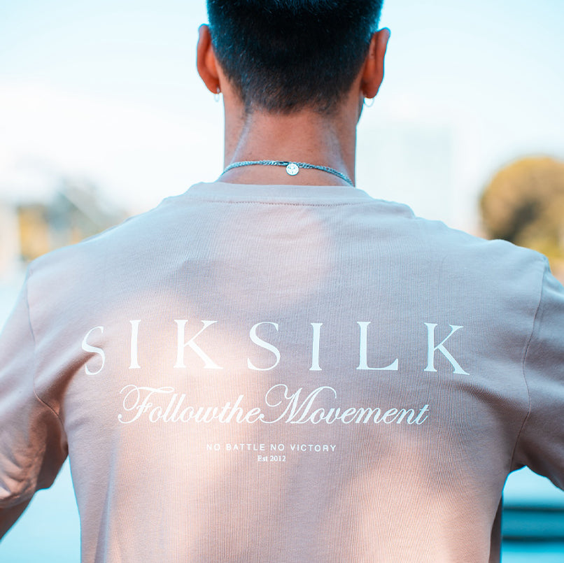 Reverse shot of model stood in the sun, wearing 
Ecru SikSilk Graphic T-Shirt