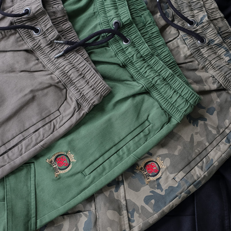 Picture of SikSilk Cargo Trousers Collection. Black, Camo, Green & Brown Cargo Trousers styles shown, all laid on top of each other